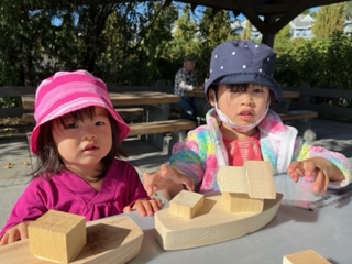 children with wooden blocks in the shape of boats